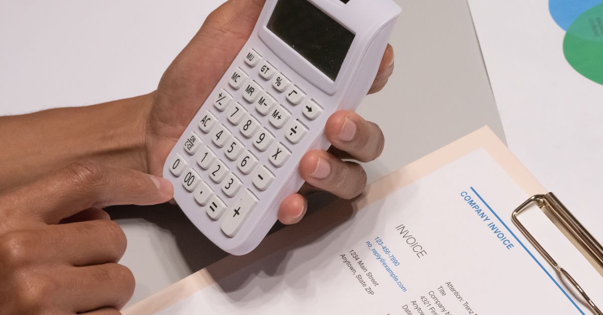 Comparaison entre micro-entreprise et régime réel sur un bureau avec calculatrice et factures