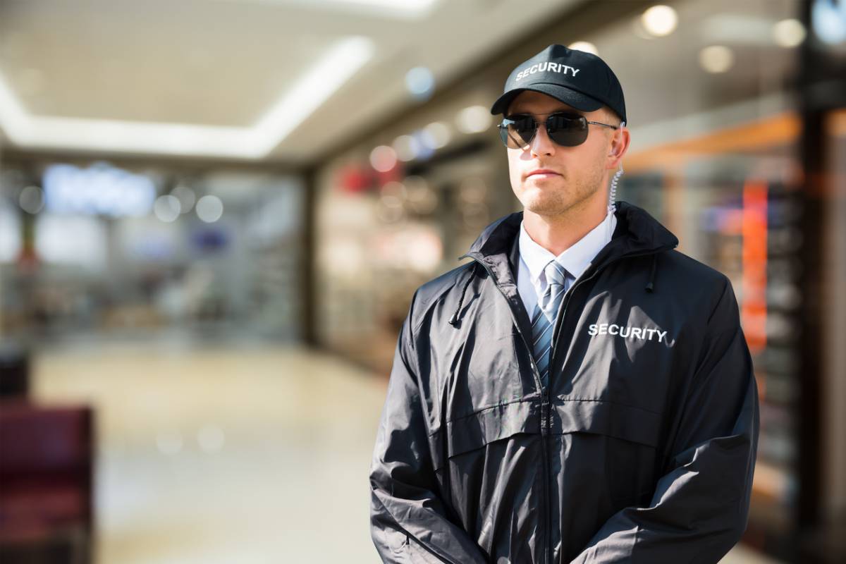 Agent de sécurité privée en veste et casquette Security dans un centre commercial
