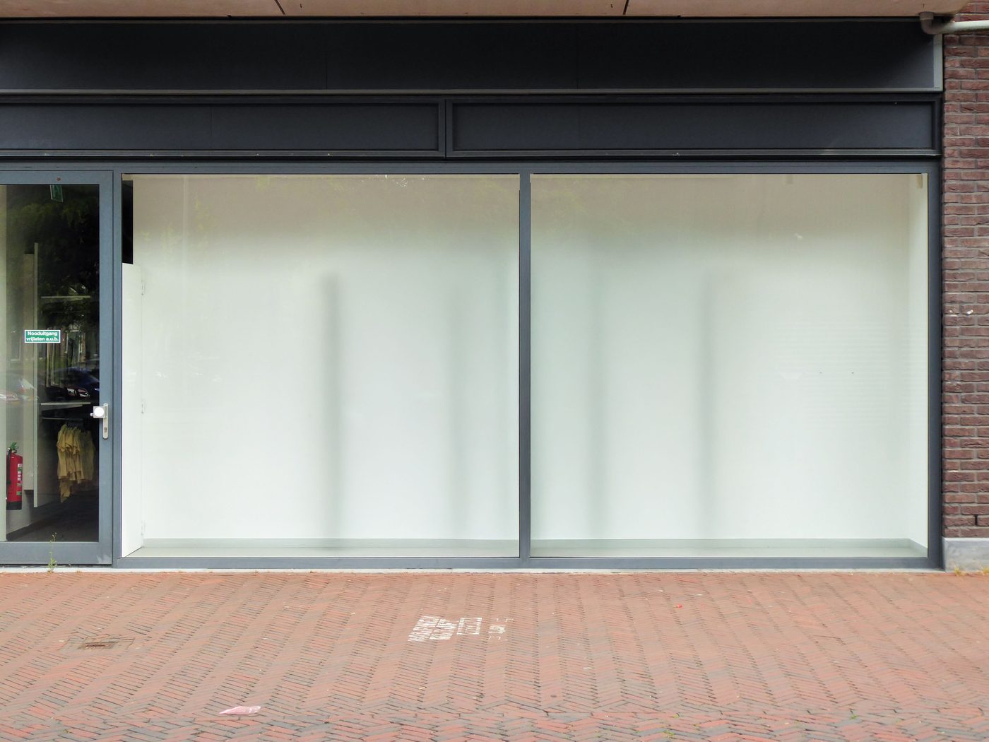 Vitrine d'un local commercial vide aux vitres dépolies, prêt à être loué